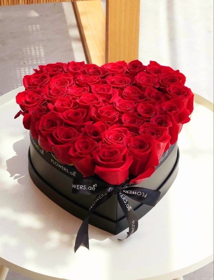 A heart shaped Black Color box containing- 50 Red Roses